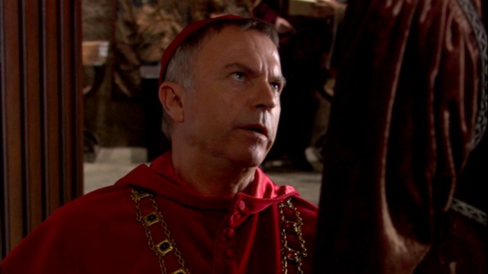 Um desesperador Cardeal Wolsey (Sam Neill) se ajoelha perante Catarina de Aragão, implorando que esta aceite a vontade do rei. 