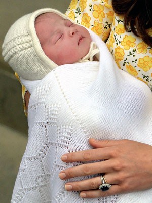 Charlotte Elizabeth Diana no colo de sua mãe, Kate. Na mão da princesa, o anel de diamantes e safiras que outrora pertenceu à mãe de William.